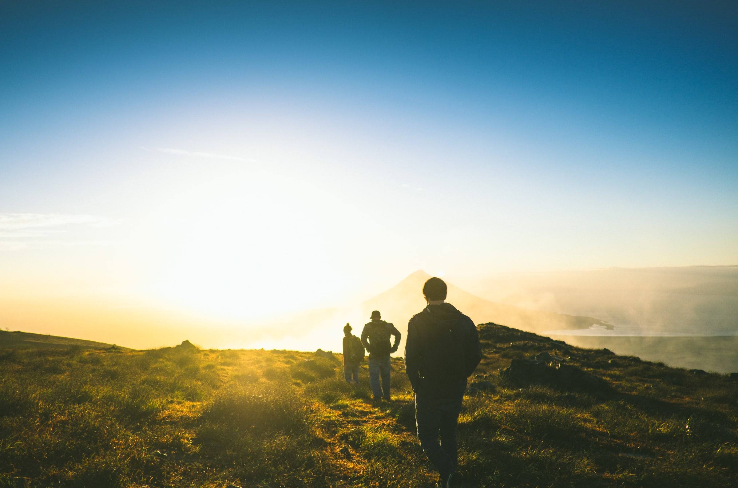 Grupo caminando hacia el amanecer